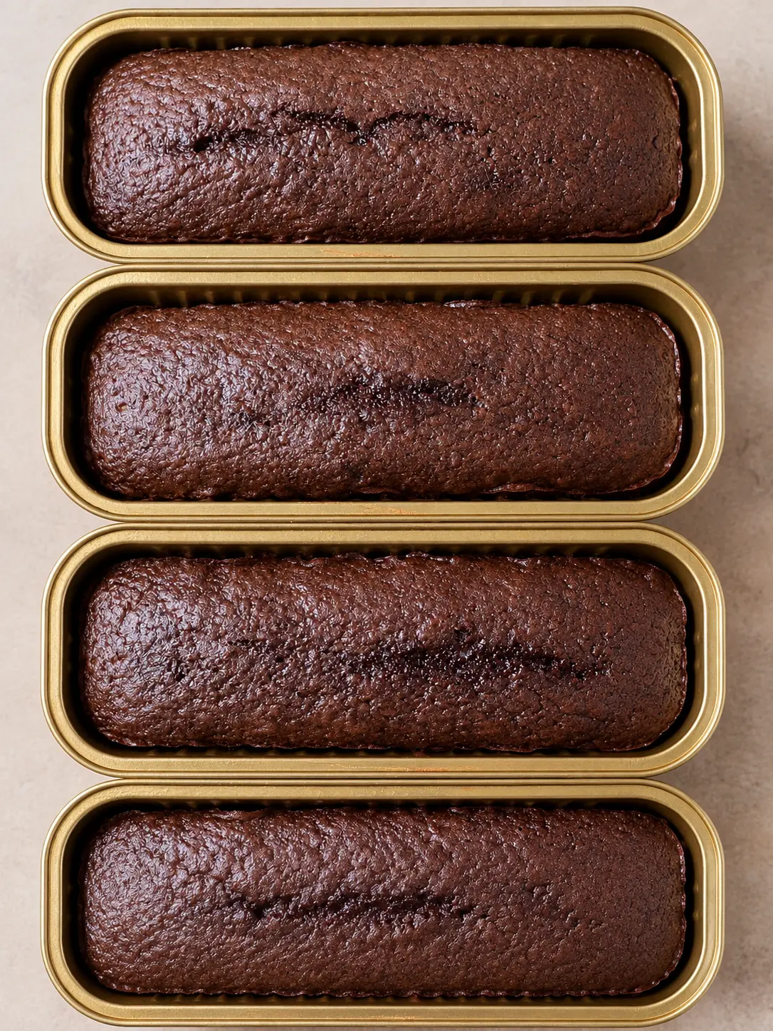 Individually packaged chocolate cakes in gold tins